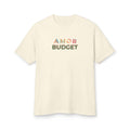 Front of the Amor Budget tee in faded cream, printed at center chest with the Amor Budget wordmark in stacked, overlapping letters in blue, teal, coral, peach and olive.